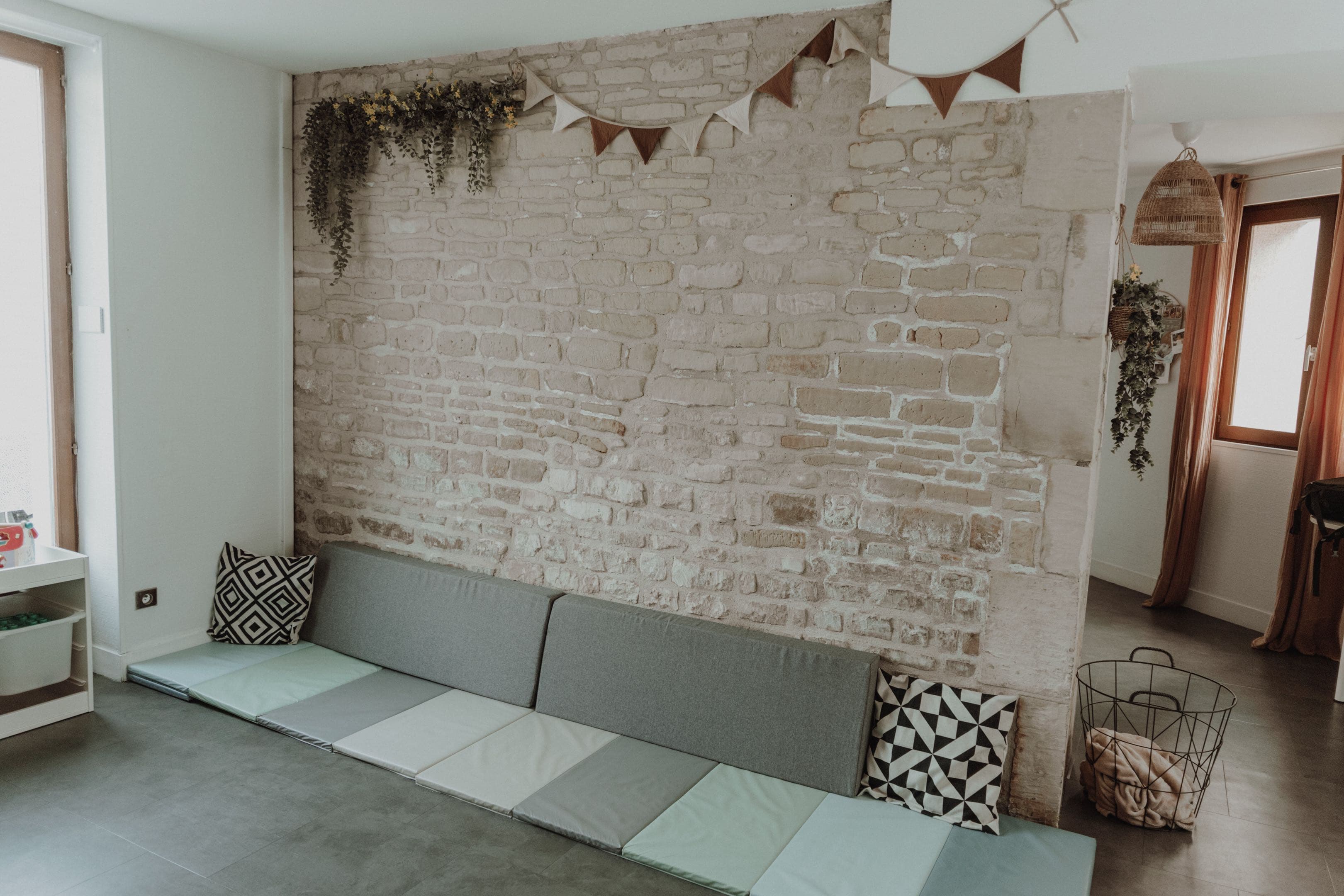 Espace intérieur du cabinet Pas à Pas, avec mur en pierre et tapis d’accueil