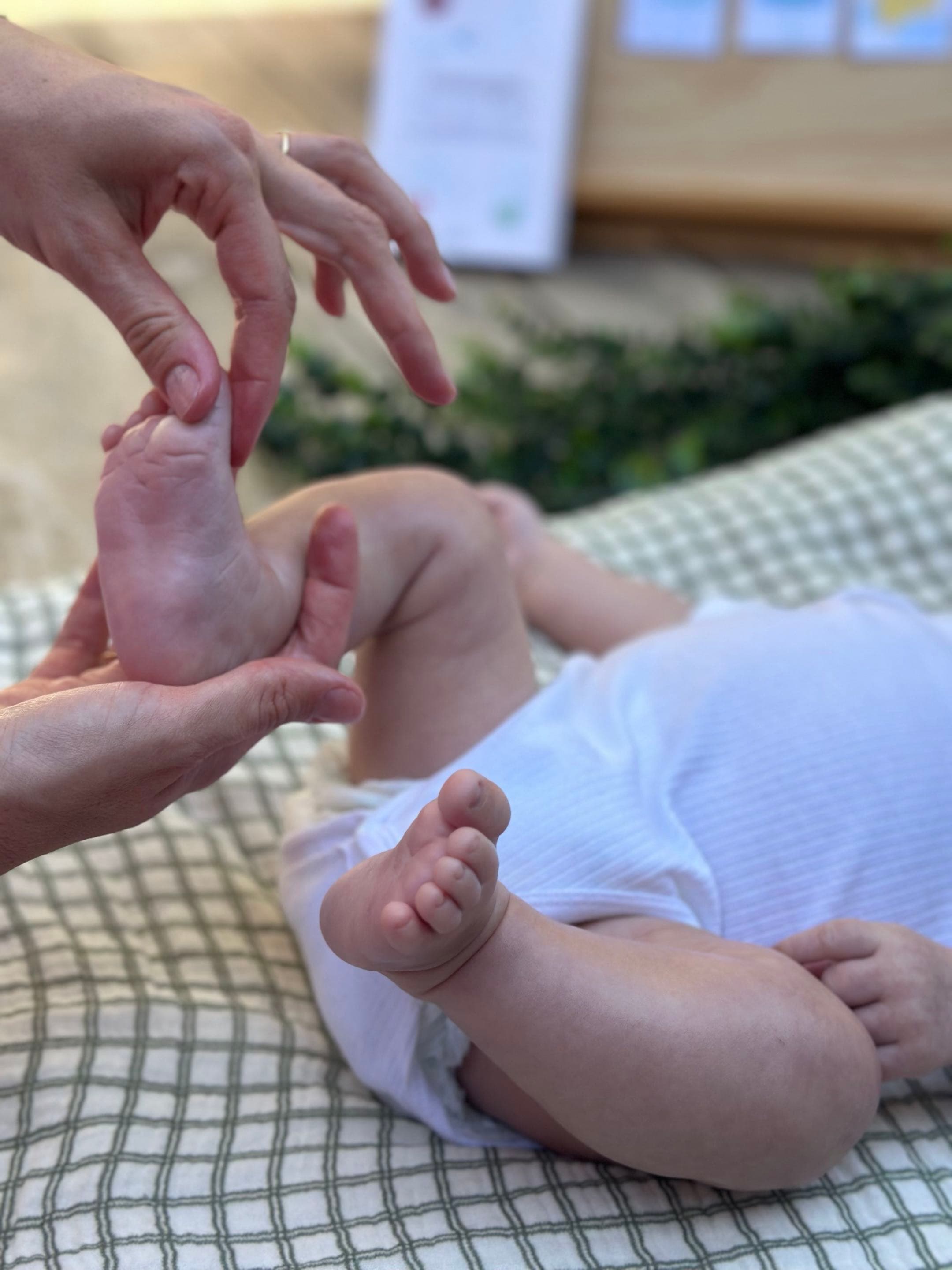 Massage doux des pieds d’un bébé accompagné par Eva